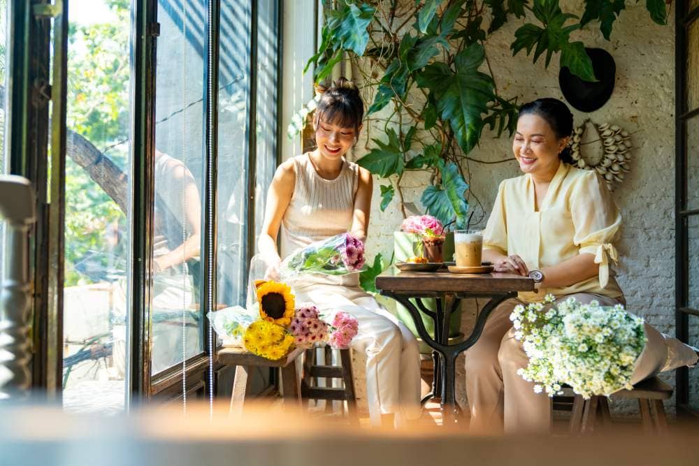 ผู้หญิงนั่งในคาเฟ่เตรียมตัวก่อนไปเที่ยวในหน้าฝน