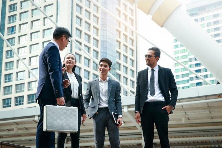 A group of business travelers walks and talks in a city