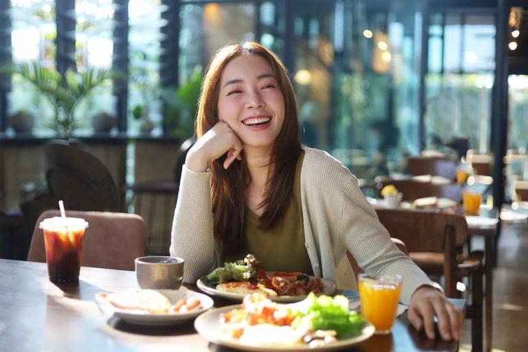 An Asian woman enjoys a good meal in a comfortable cafe in Sathorn