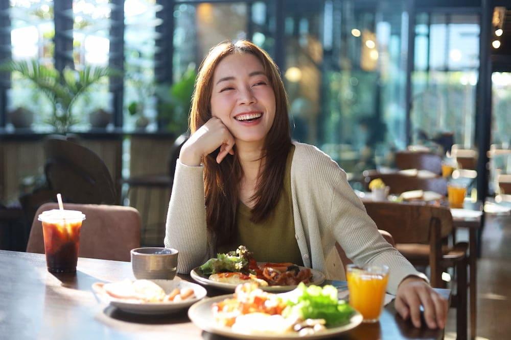 An Asian woman enjoys a good meal in a comfortable cafe in Sathorn