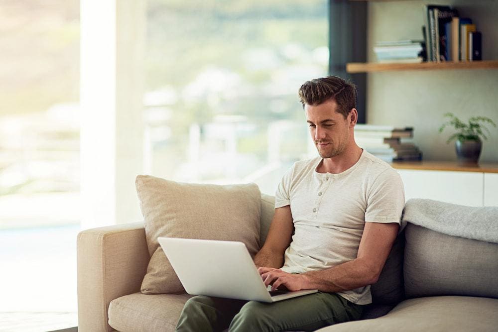 A digital nomad working on his laptop in a comfortable hotel in Bangkok.
