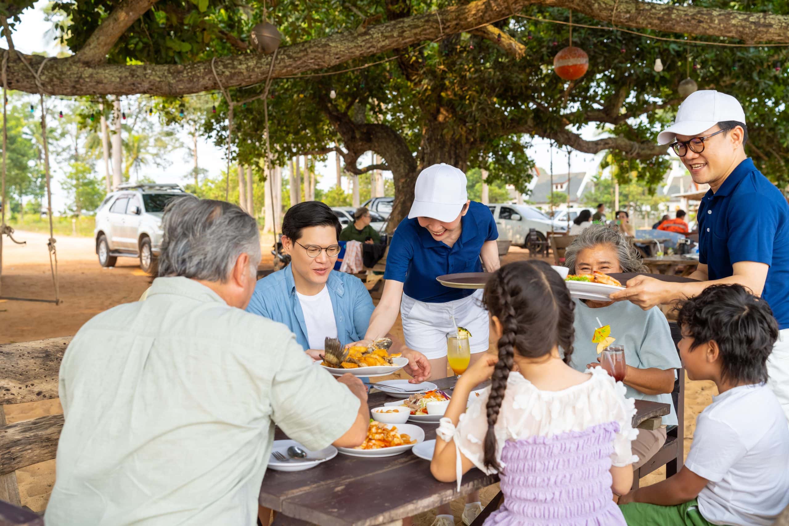 A relaxed family vacation with grandparents over a shared outdoor lunch in Bangkok