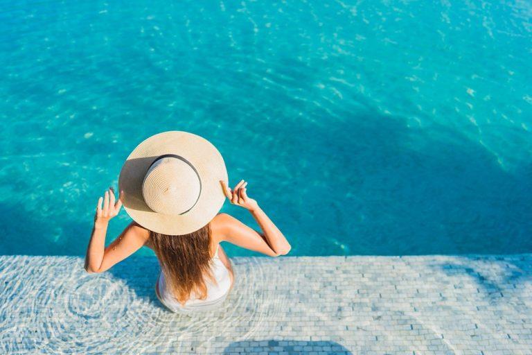 A hotel guest relaxing after comparing an inground vs rooftop pool for the stay