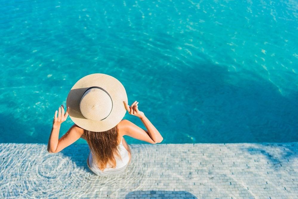 A hotel guest relaxing after comparing an inground vs rooftop pool for the stay